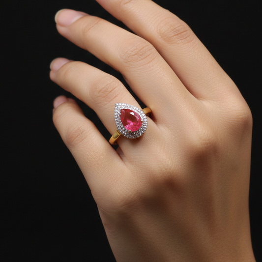 Hand wearing a ring with a pink gemstone on a black background