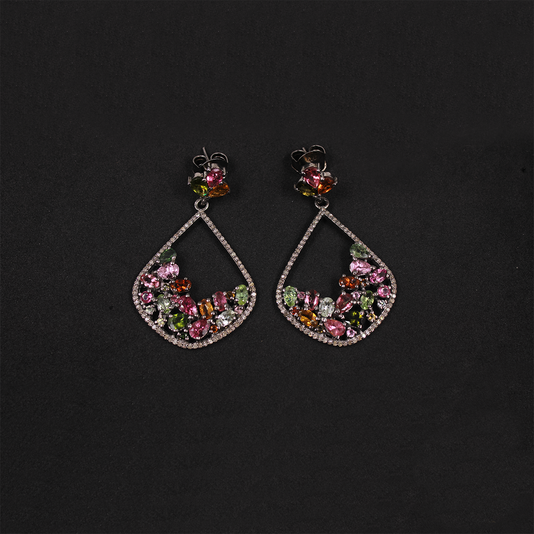 Pair of earrings with colorful gemstones on a black background