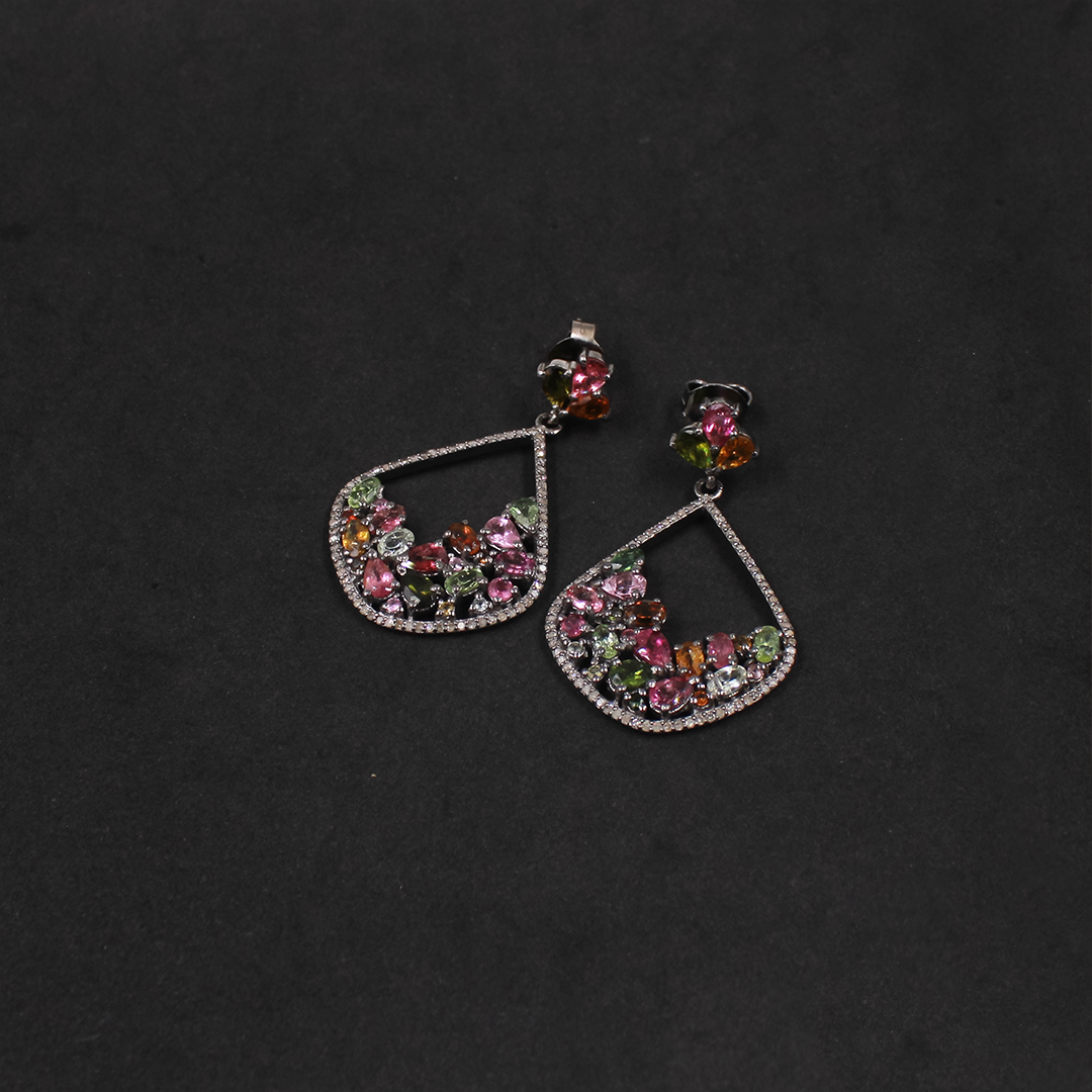 Pair of earrings with colorful gemstones on a dark background