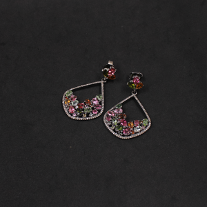 Pair of earrings with colorful gemstones on a dark background