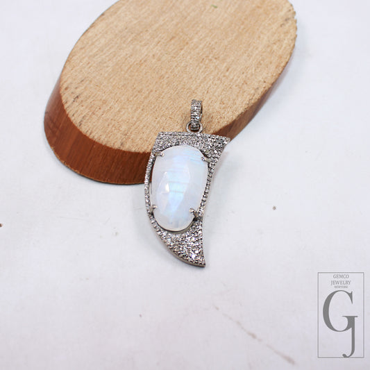 A shark tooth-shaped natural moonstone pendant charm with 925 sterling silver rose-cut pave diamond and handmade finish on a wooden display stand.