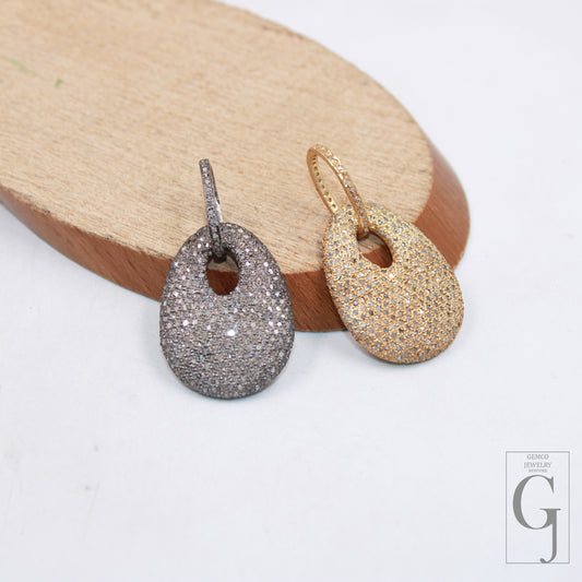 Two dog tag pendants with 925 sterling silver, one with a rose cut pave diamond surface, and the other with a clear, sparkling diamond surface, displayed against a wooden background.
