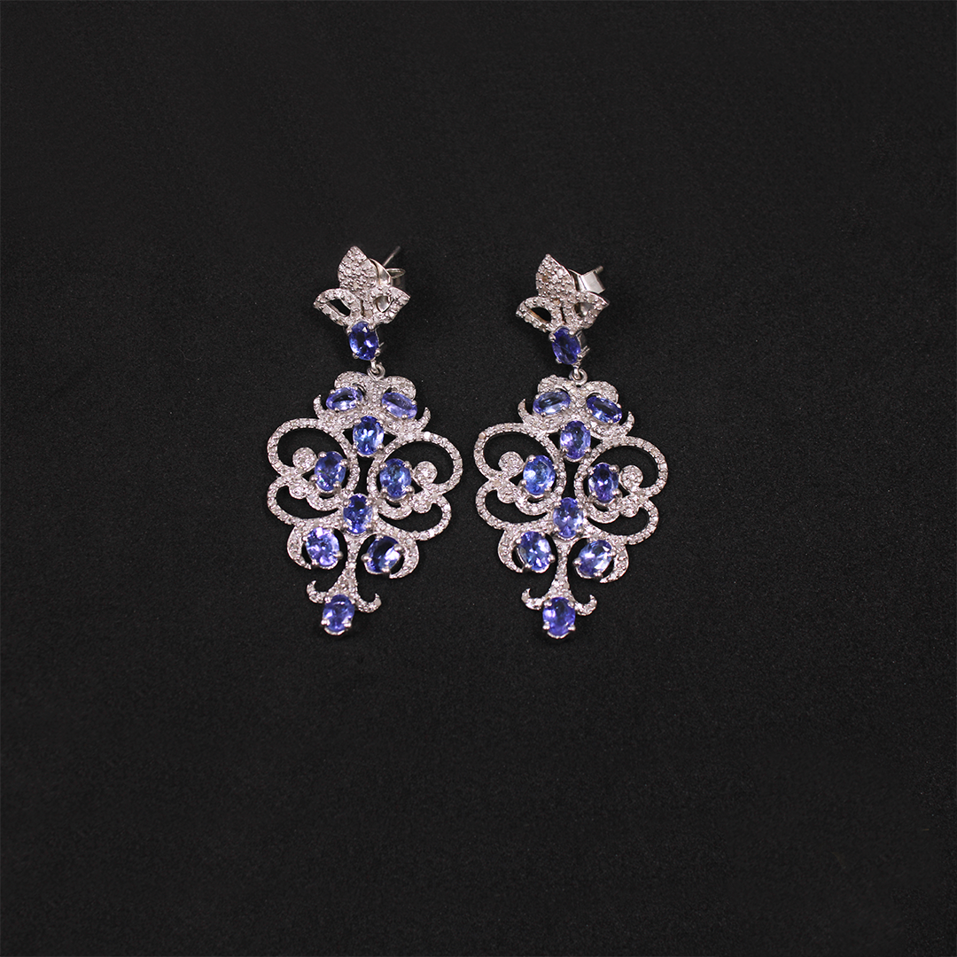 Pair of silver earrings with blue gemstones on a black background