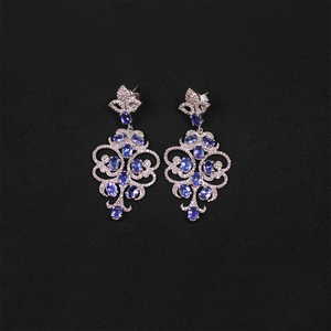 Pair of silver earrings with blue gemstones on a black background