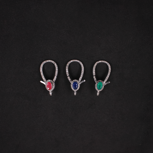 Three pairs of earrings with gemstones on a black background