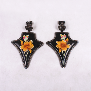 Pair of black earrings with floral designs on a white background