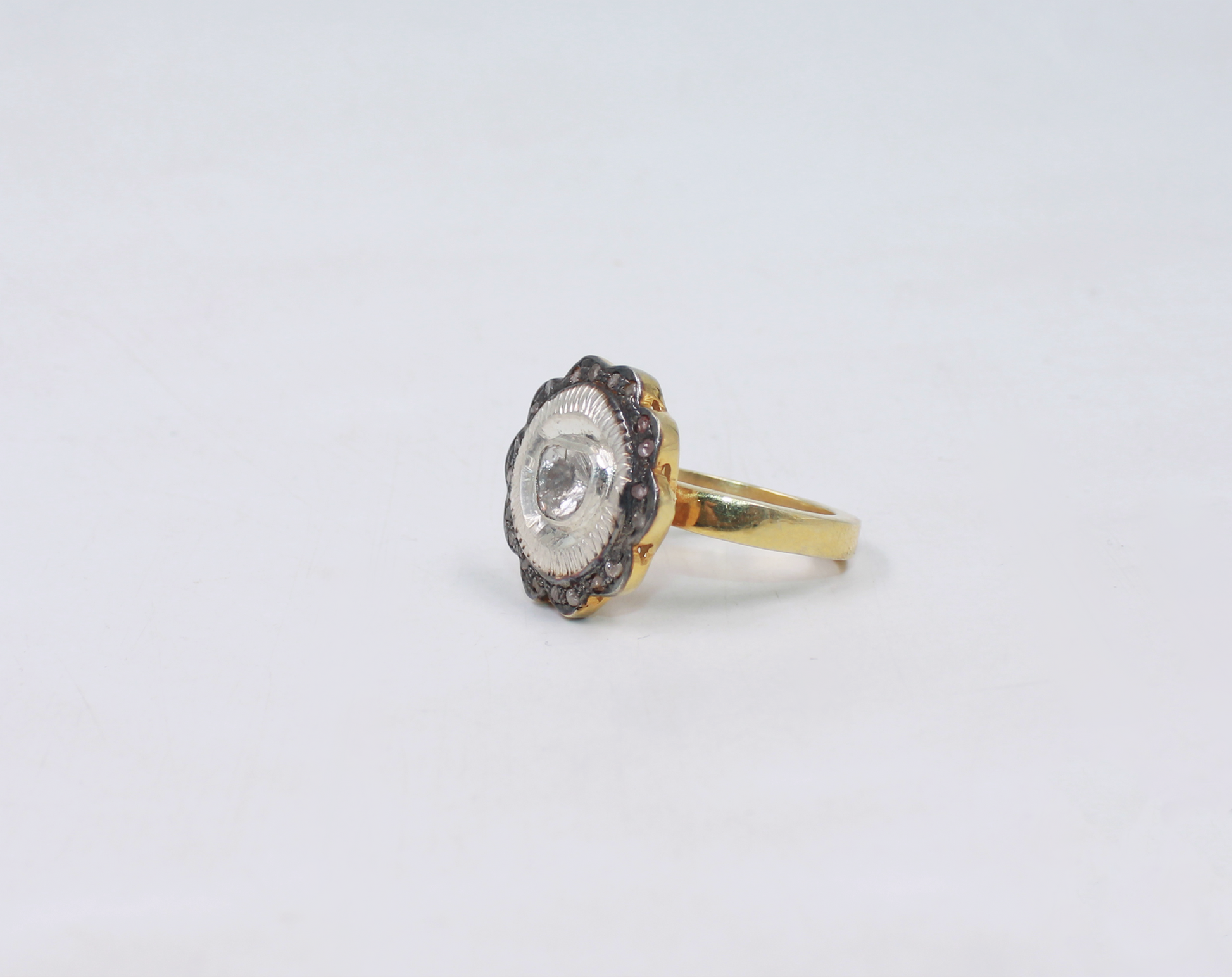 Gold ring with a diamond on a light gray background