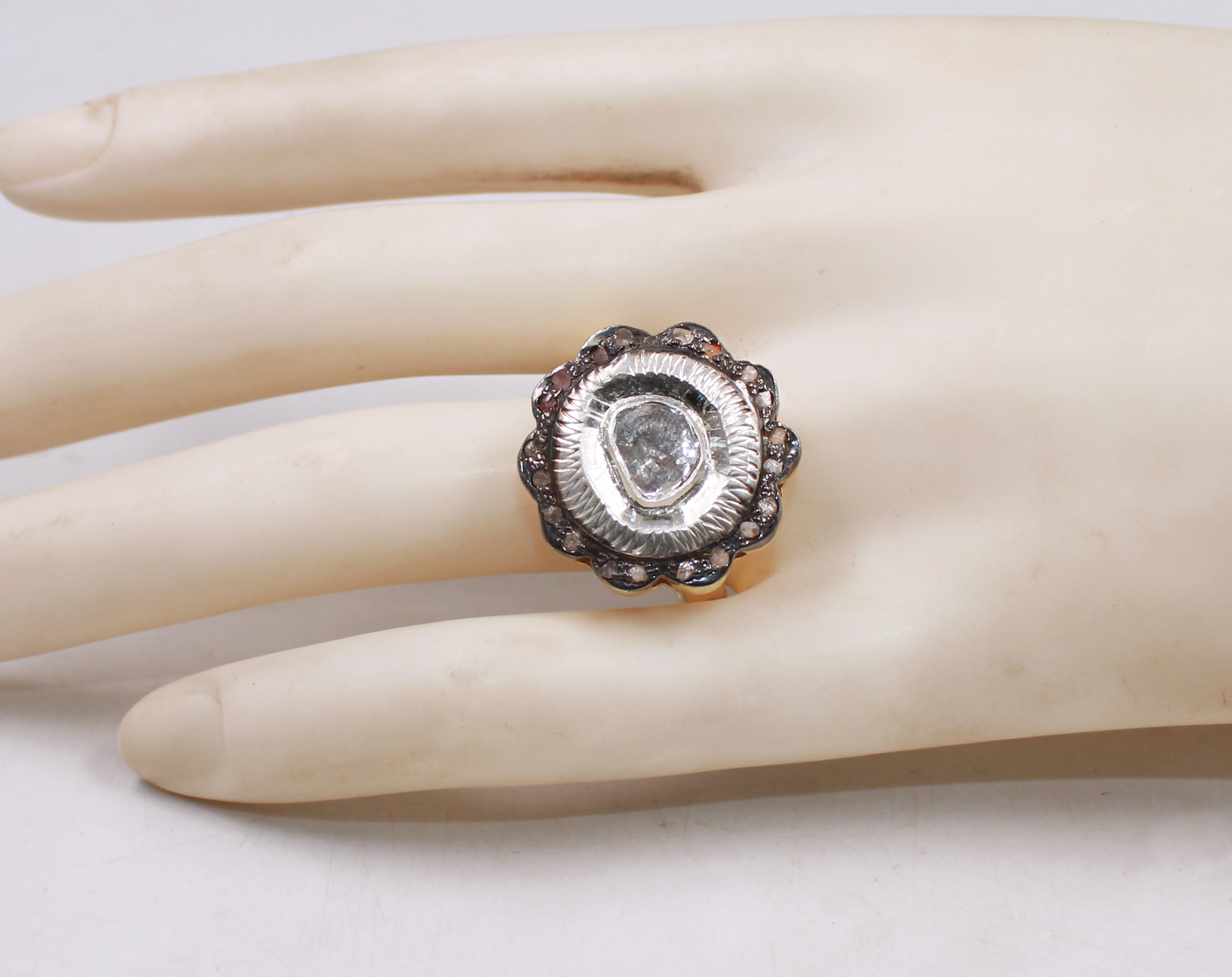 Silver ring with a large central stone on a mannequin hand