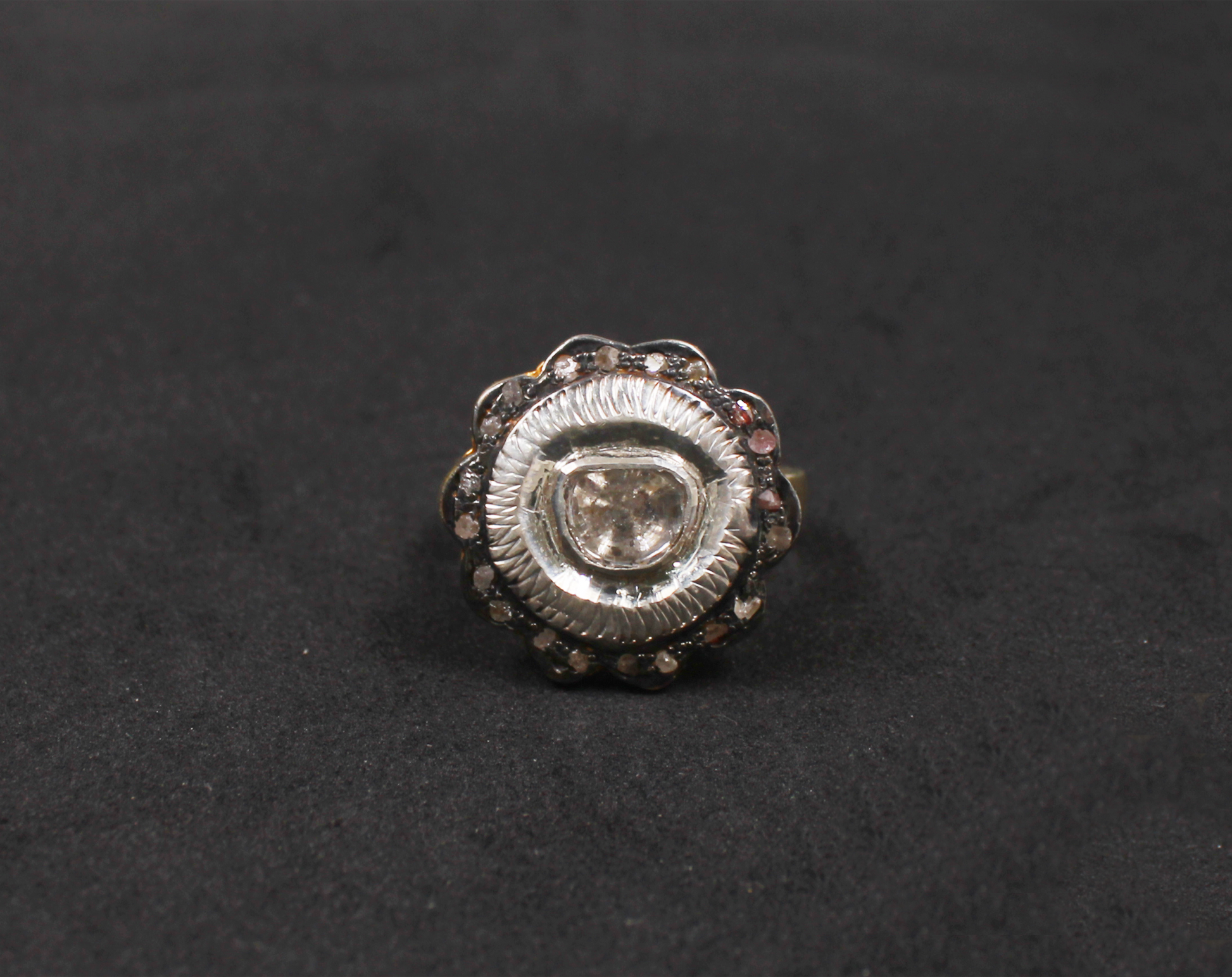 Silver ring with a central gemstone on a black background