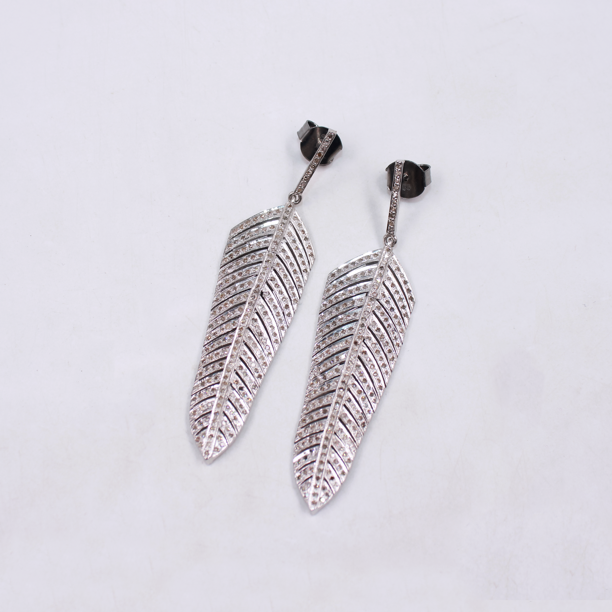 Polished sterling silver earrings with diamond feather pattern