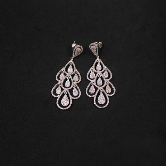Pair of silver chandelier earrings on a black background