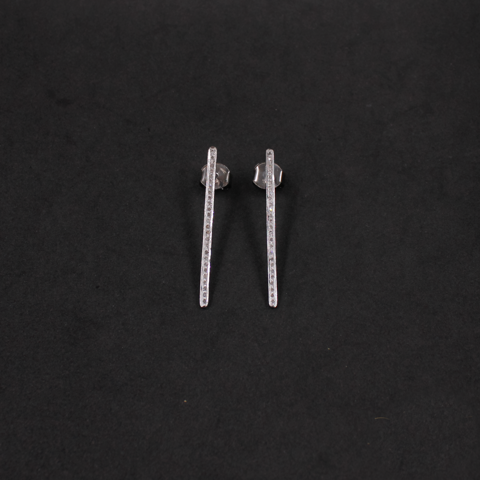 Pair of silver bar earrings on a black background
