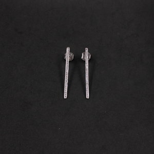 Pair of silver bar earrings on a black background