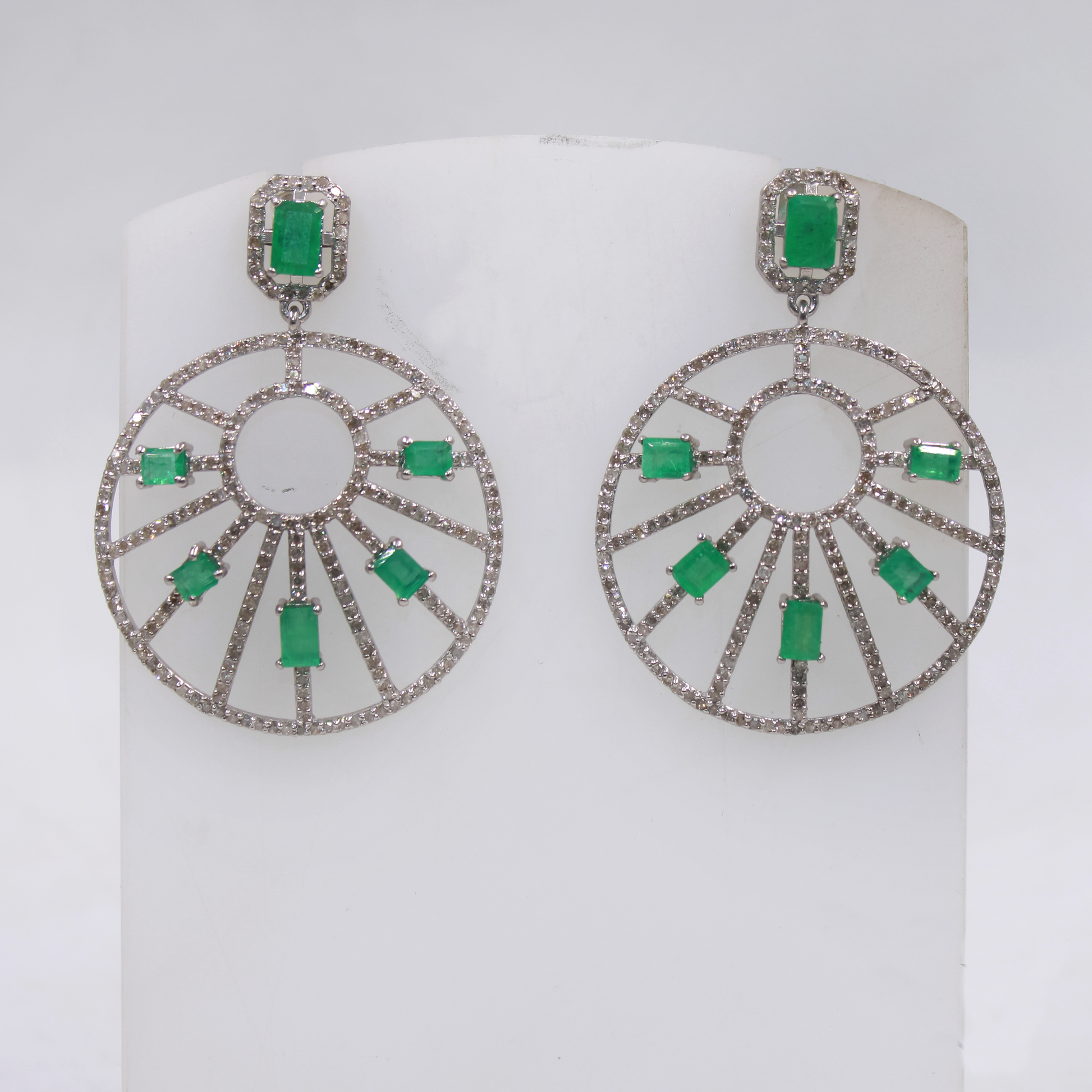 Pair of earrings with green gemstones on a white background