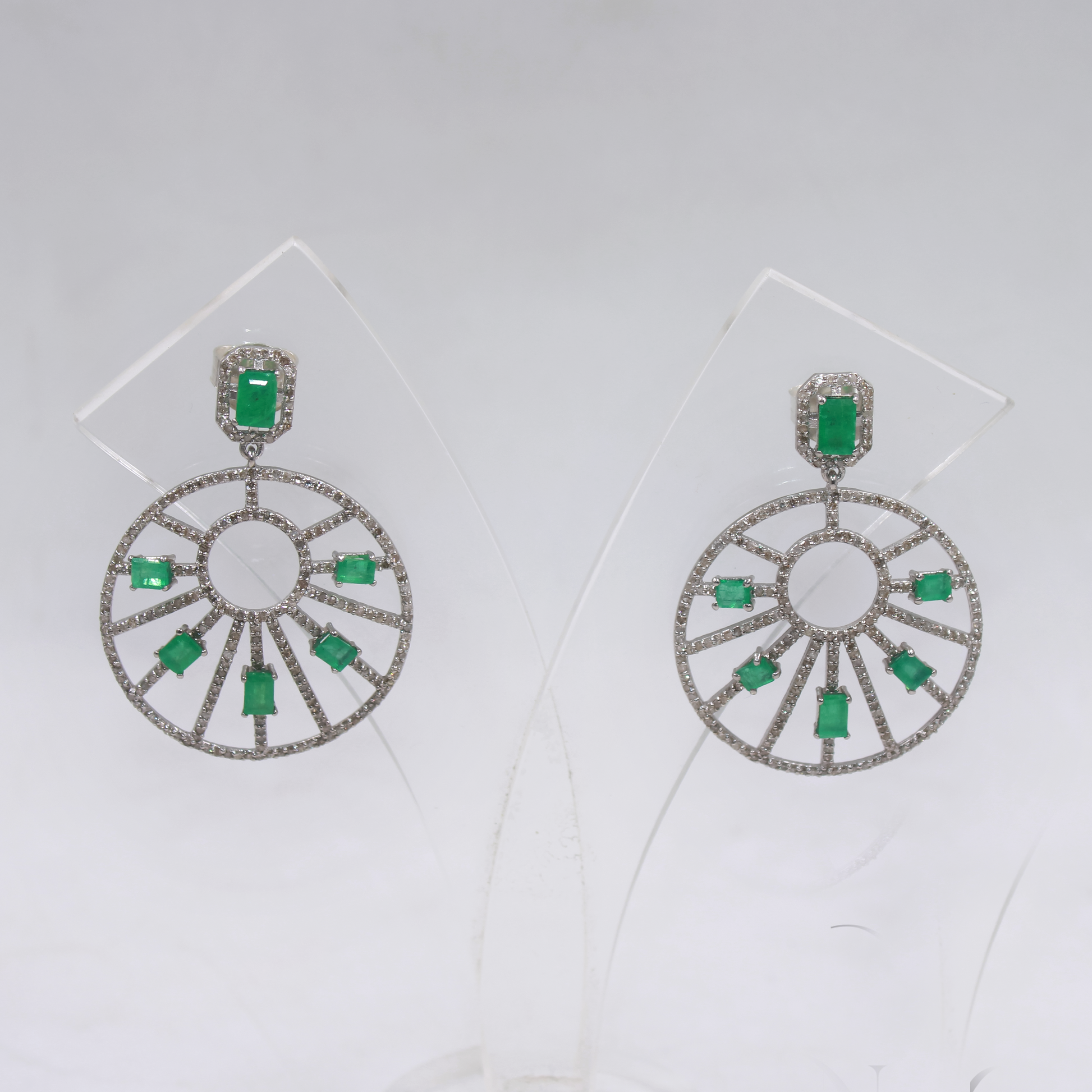 Pair of earrings with green gemstones on a white background