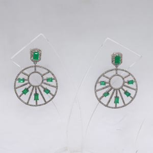 Pair of earrings with green gemstones on a white background