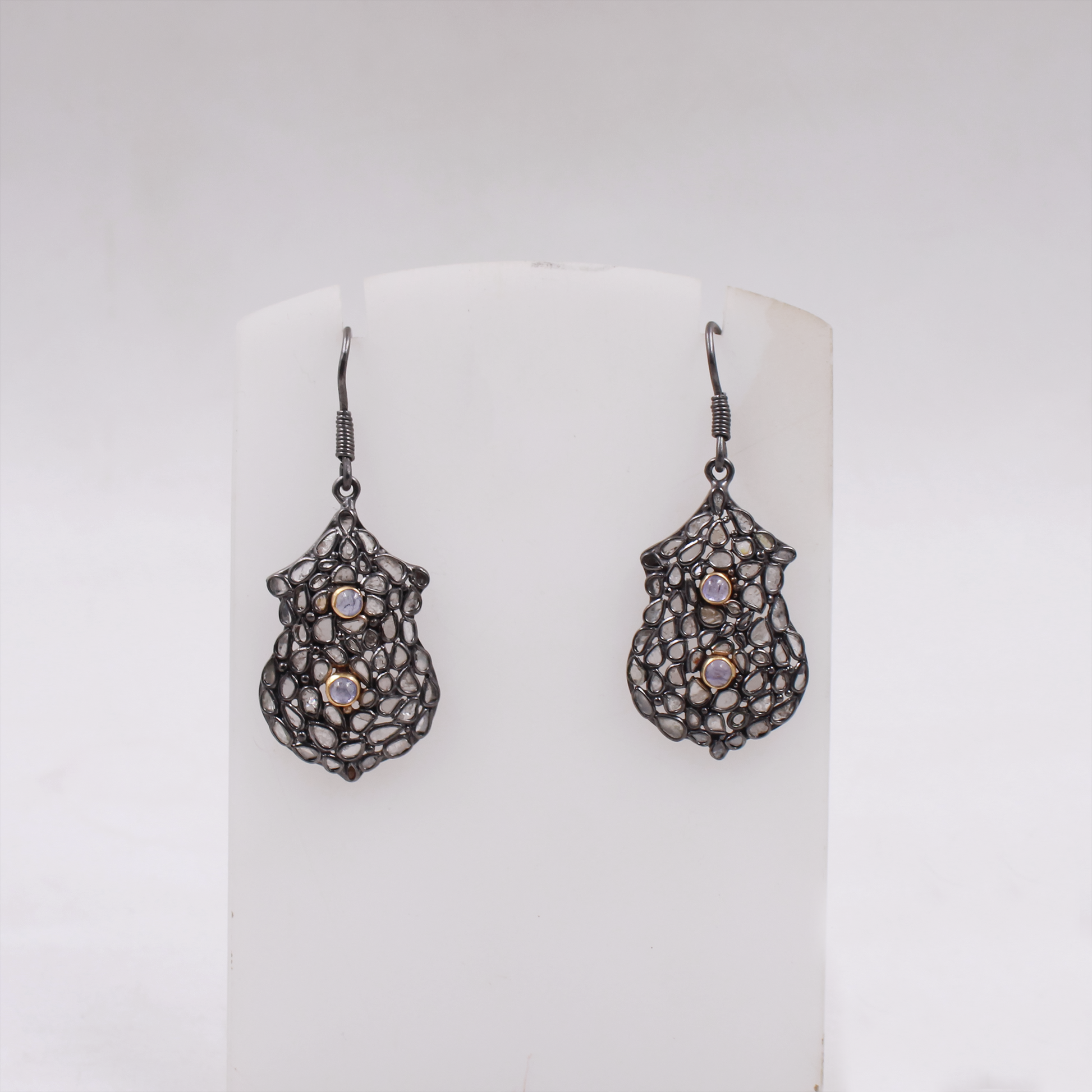 Pair of silver earrings with intricate designs on a white background