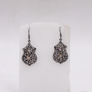 Pair of silver earrings with intricate designs on a white background