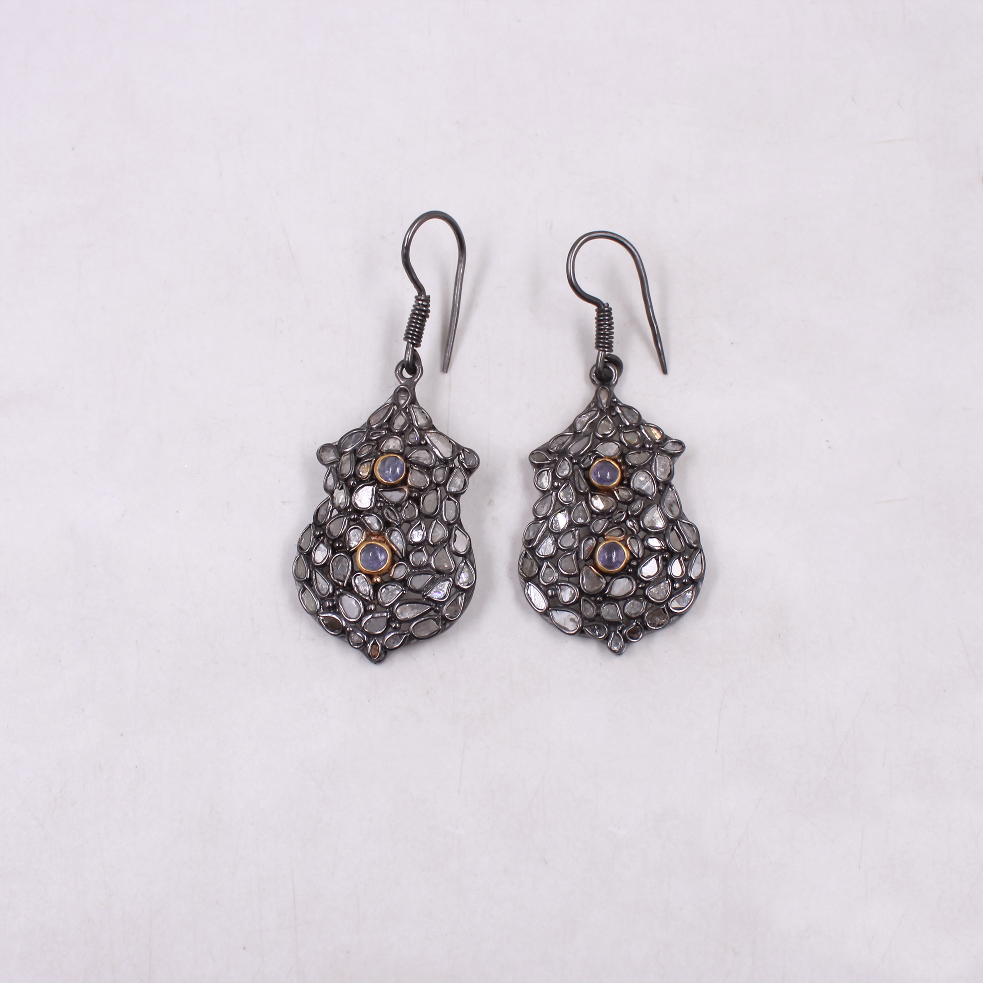 Pair of ornate earrings on a light gray background