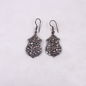 Pair of ornate earrings on a light gray background
