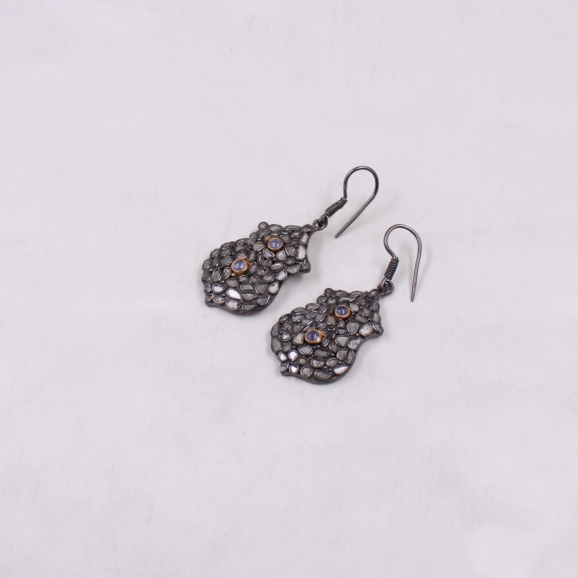 Pair of ornate earrings on a light gray background