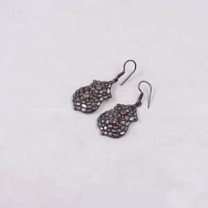 Pair of ornate earrings on a light gray background