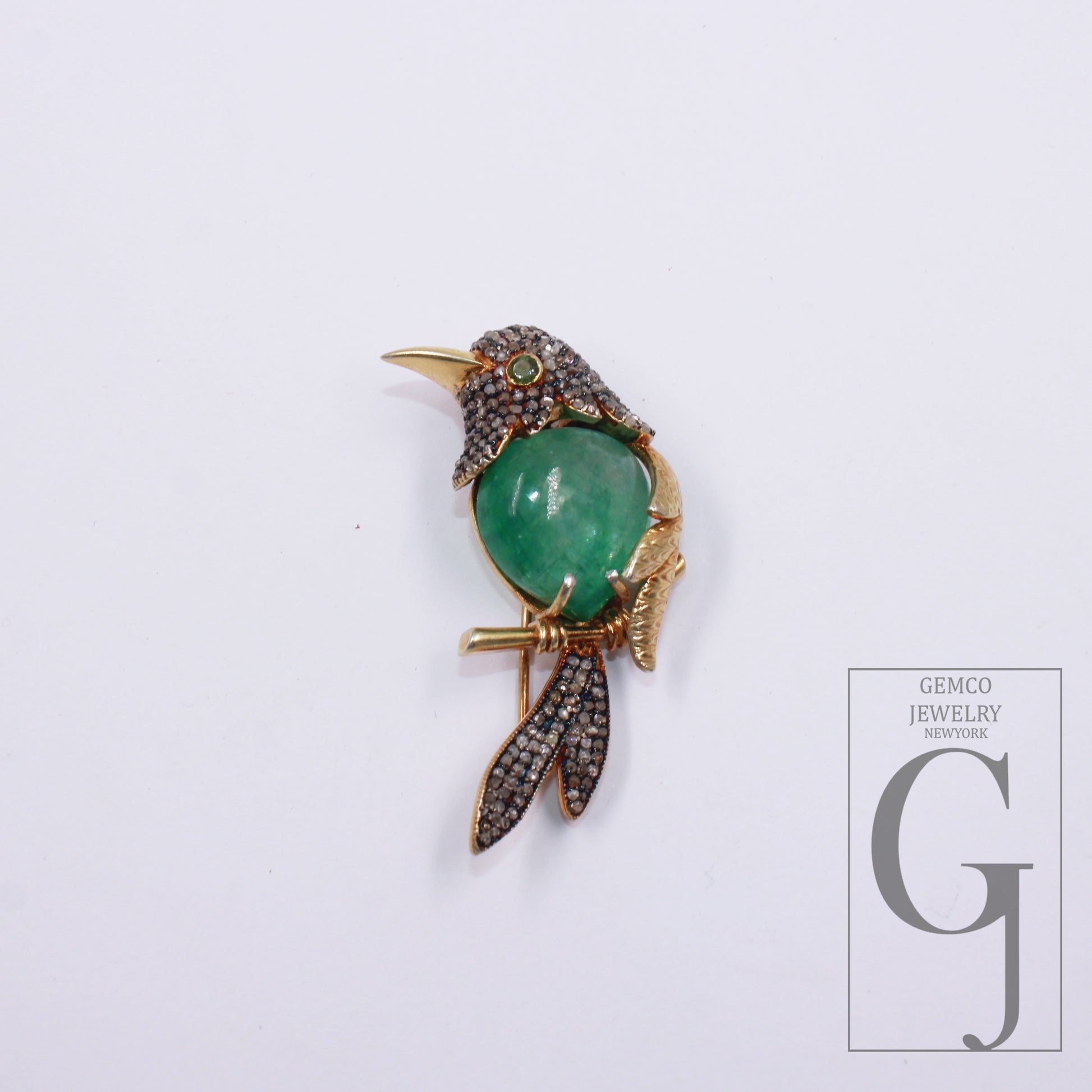 Close-up of emerald bird brooch with rosecut diamonds