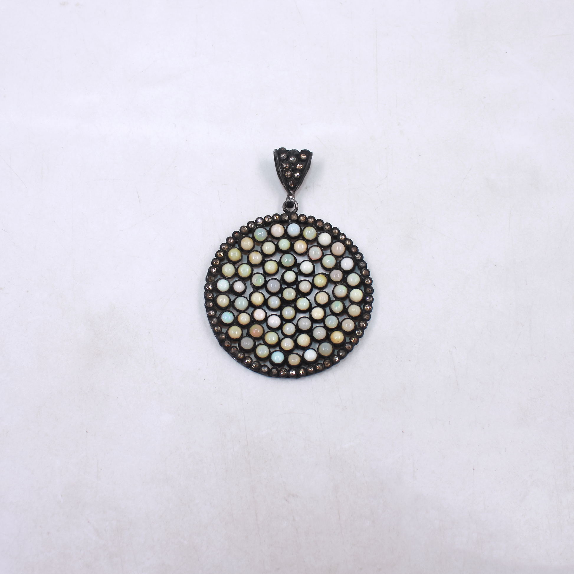 Round pendant with bead-like design on a white background