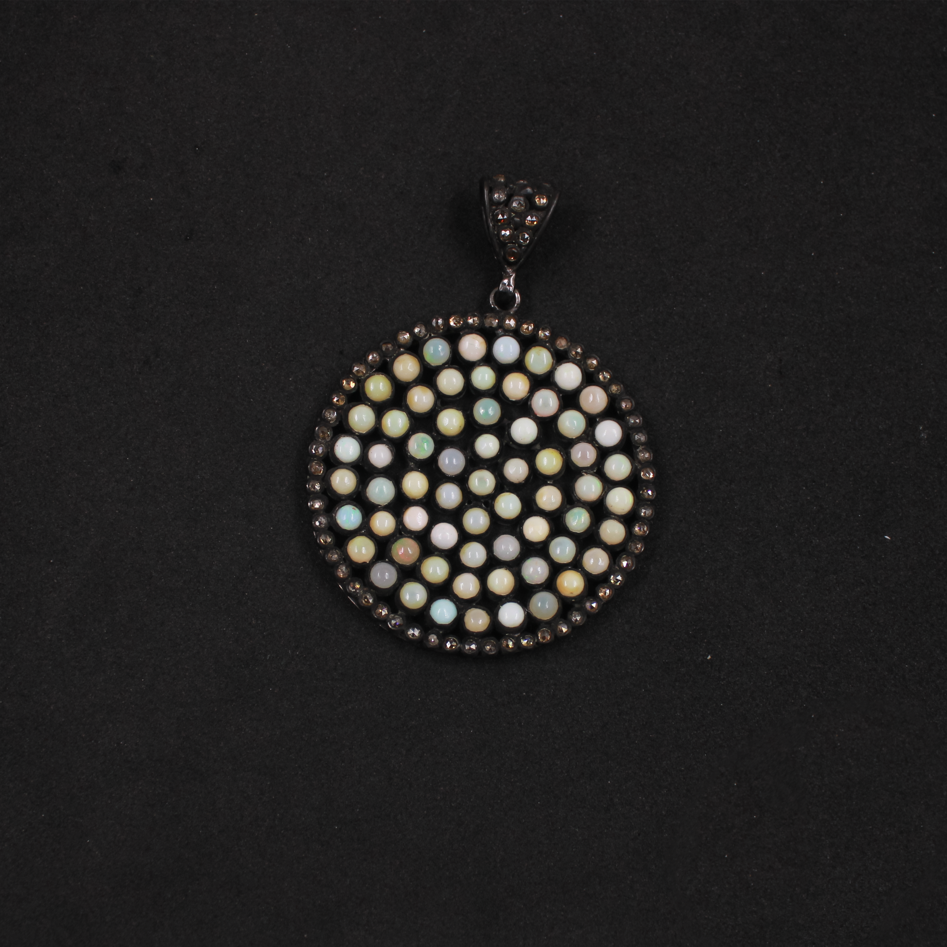 Round pendant with multicolored stones on a black background