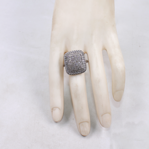 Silver ring with gemstones on a mannequin hand against a white background