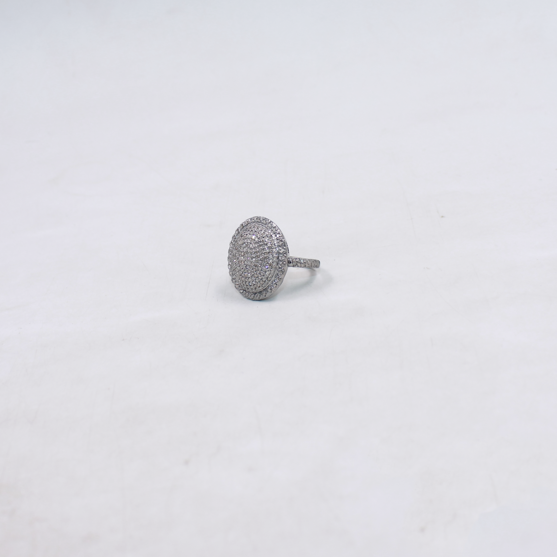Silver ring with a textured design on a light gray background