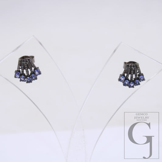 This image displays a pair of elegant earrings, presented in a clear, protective case that enhances their vibrant colors and intricate design. The earrings feature a striking combination of blue and clear beads, with a central, ornate ring that adds sophistication to the overall aesthetic.
