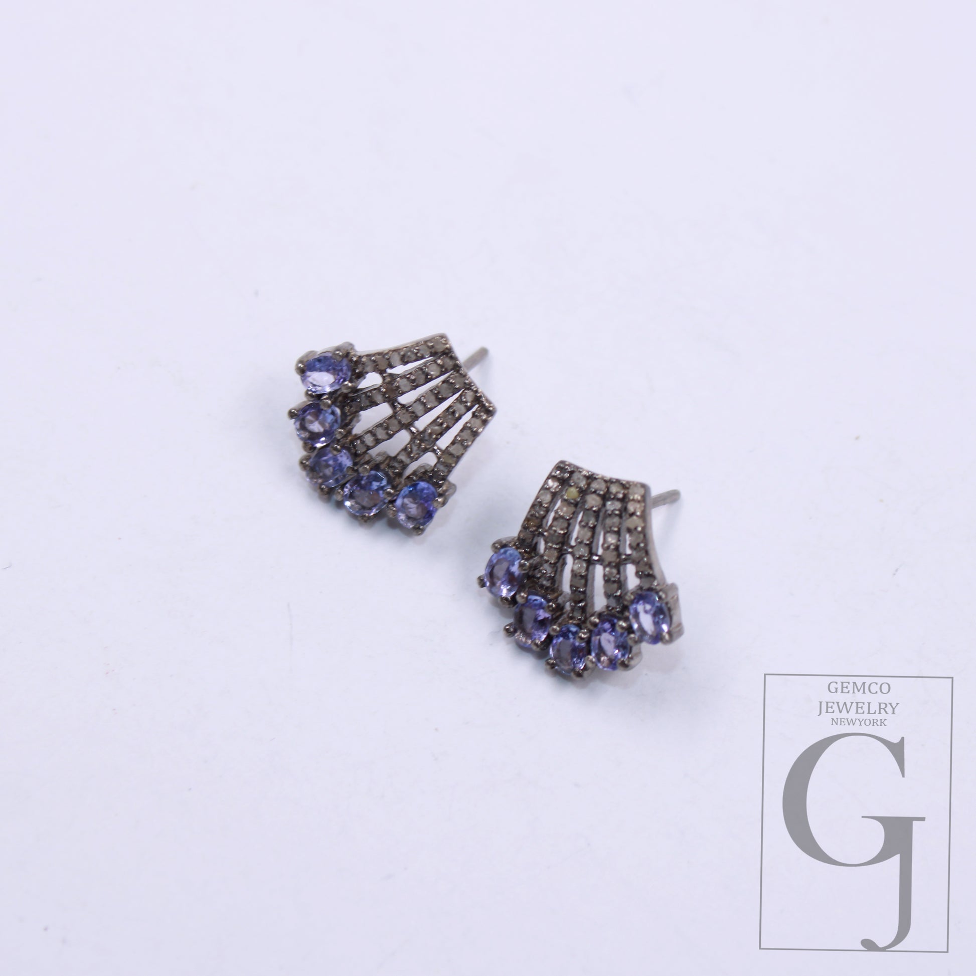 Close-up of handcrafted tanzanite and rosecut diamond stud earrings 