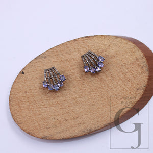 Elegant small stud earrings with purple tanzanites and rosecut diamonds – close-up.