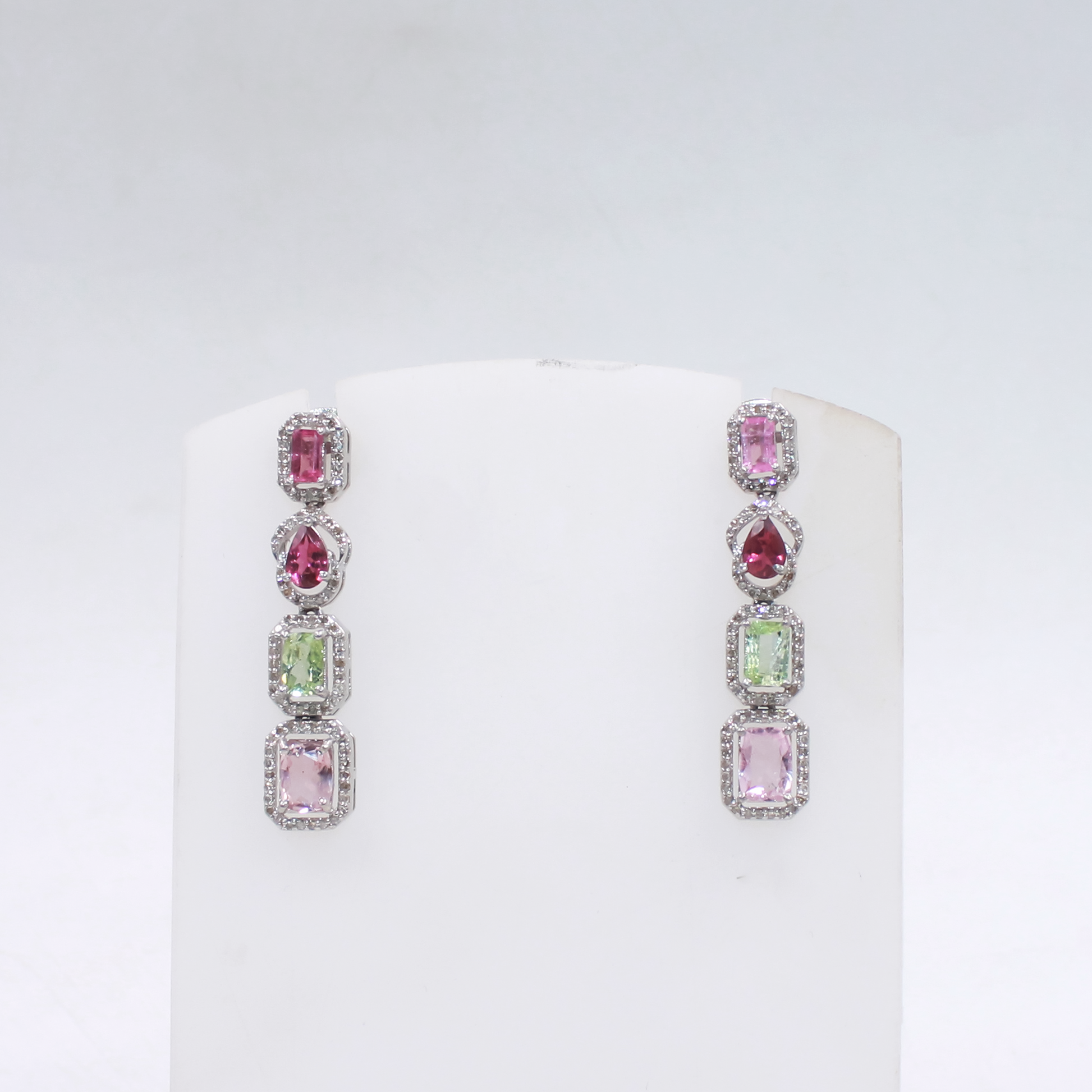 Long gemstone earrings featuring emerald cut, oval, and cushion tourmalines