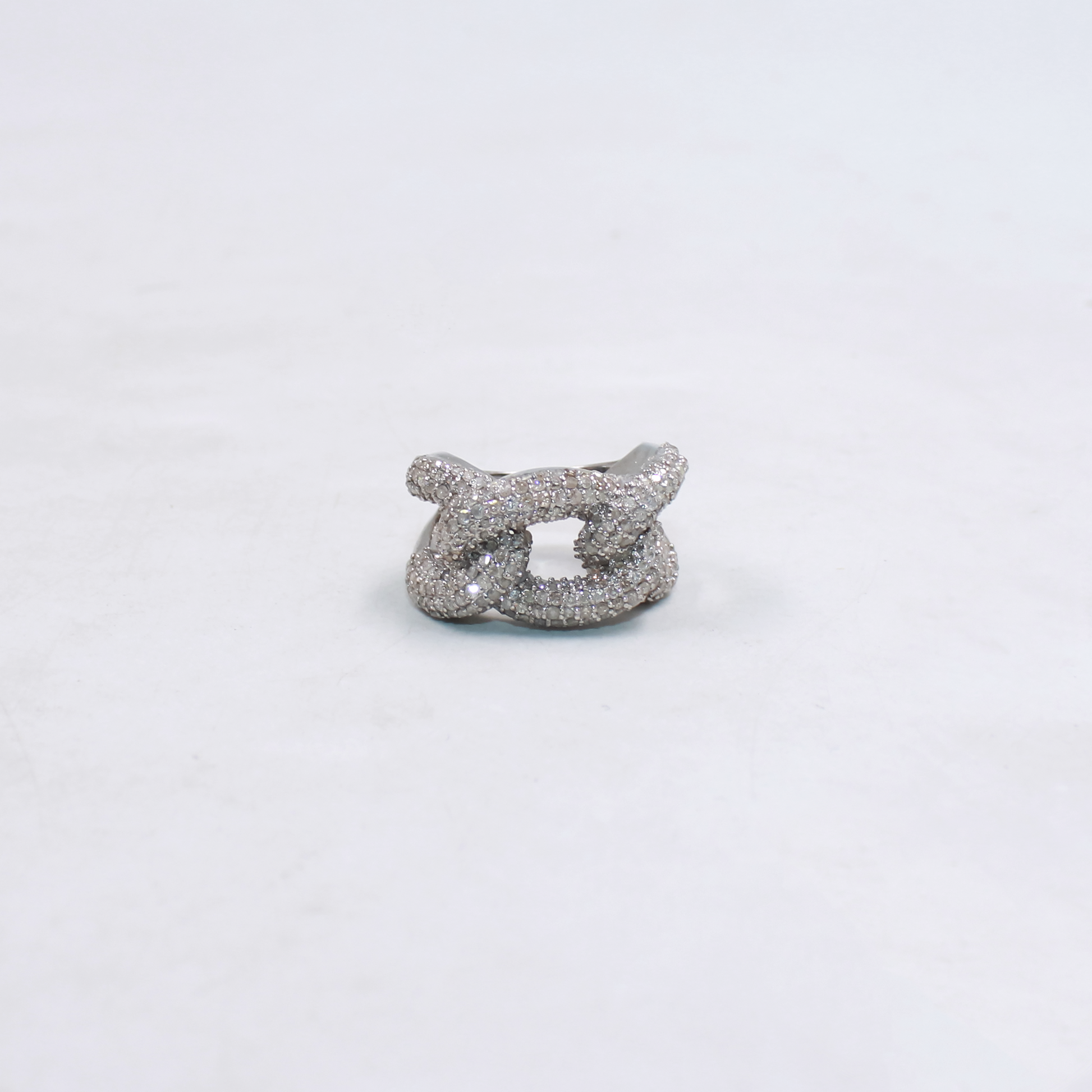 Silver jewelry piece on a light gray background