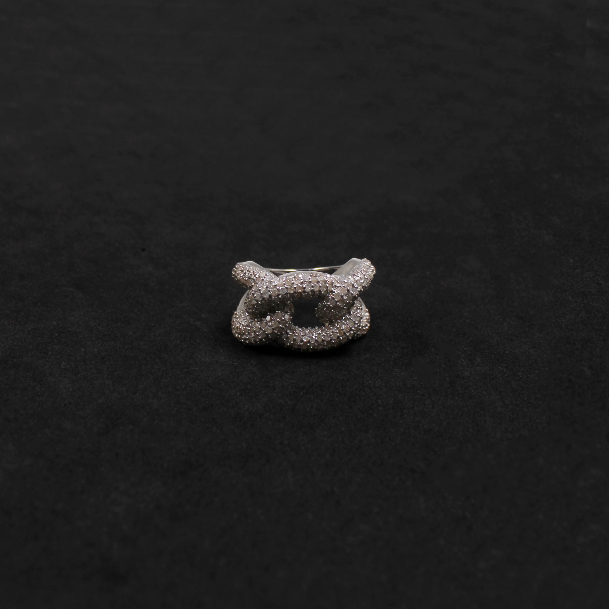 Silver ring with a textured design on a black background