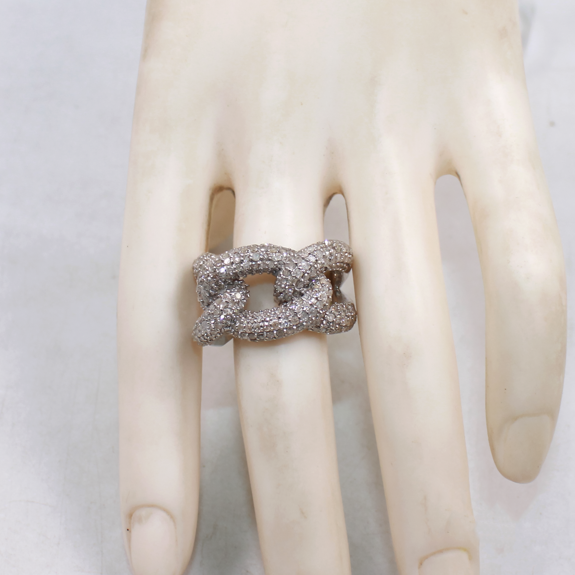 Silver ring on a mannequin hand against a white background