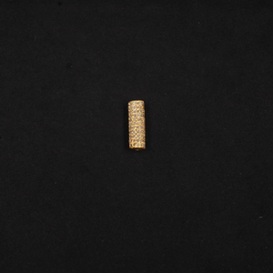 Gold cylindrical bead on a black background