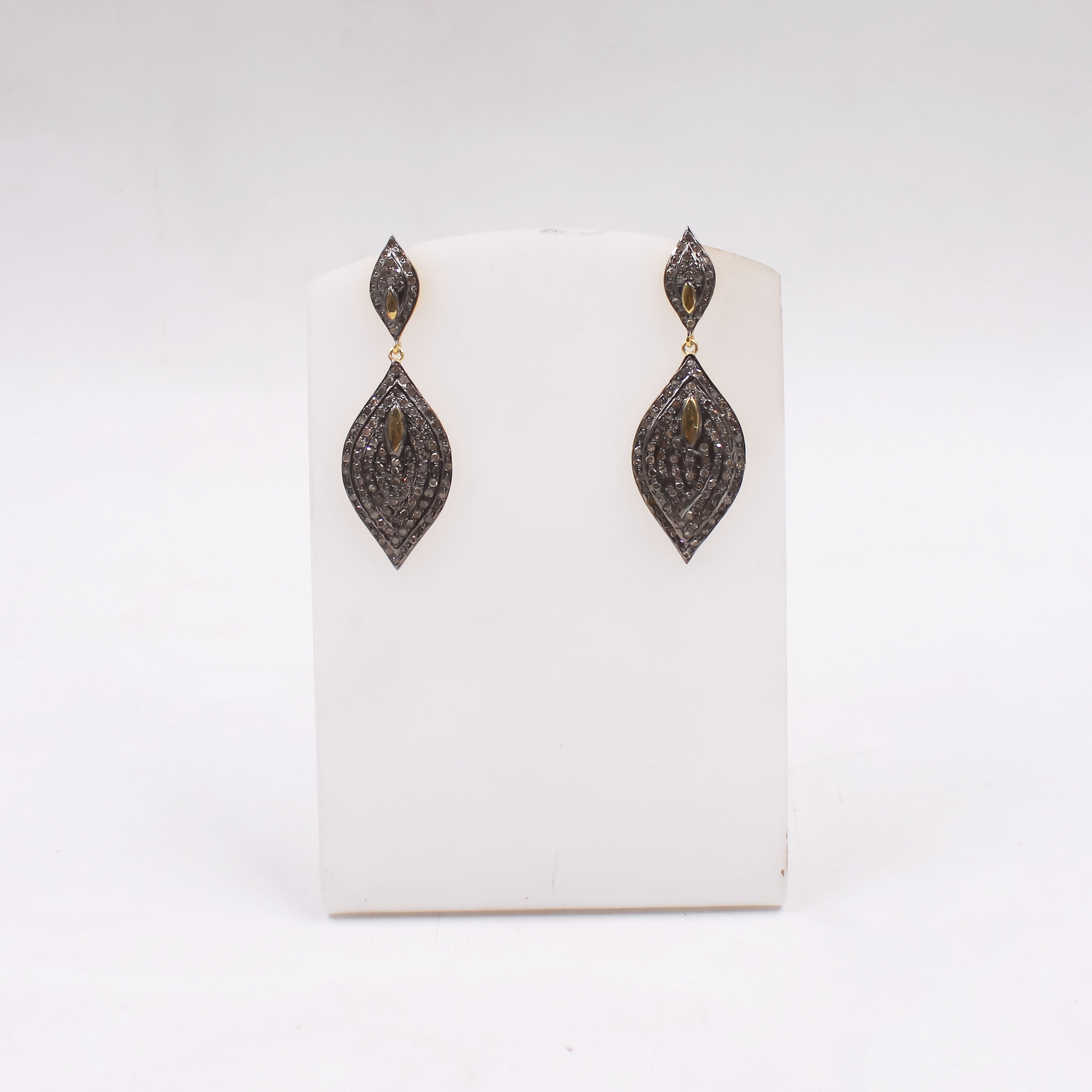 Pair of black diamond earrings on a white card with a white background