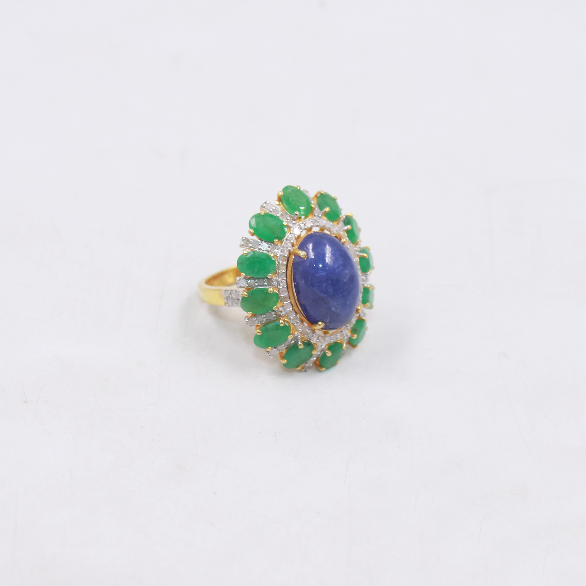 Bold gemstone cocktail ring featuring blue kyanite and green emeralds
