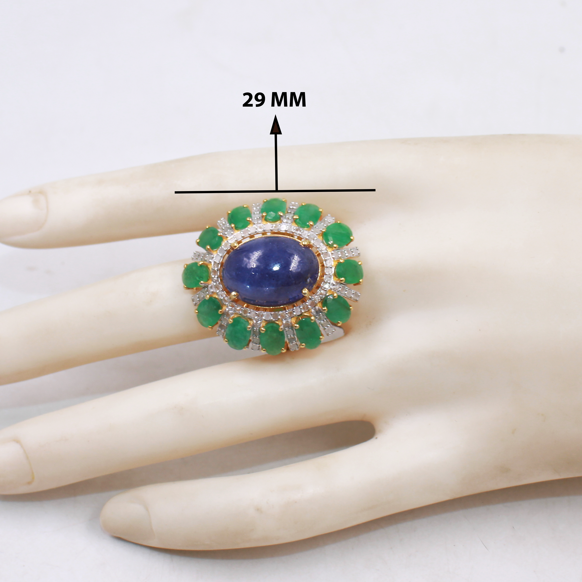 Oval blue kyanite cocktail ring with emerald and diamond halo