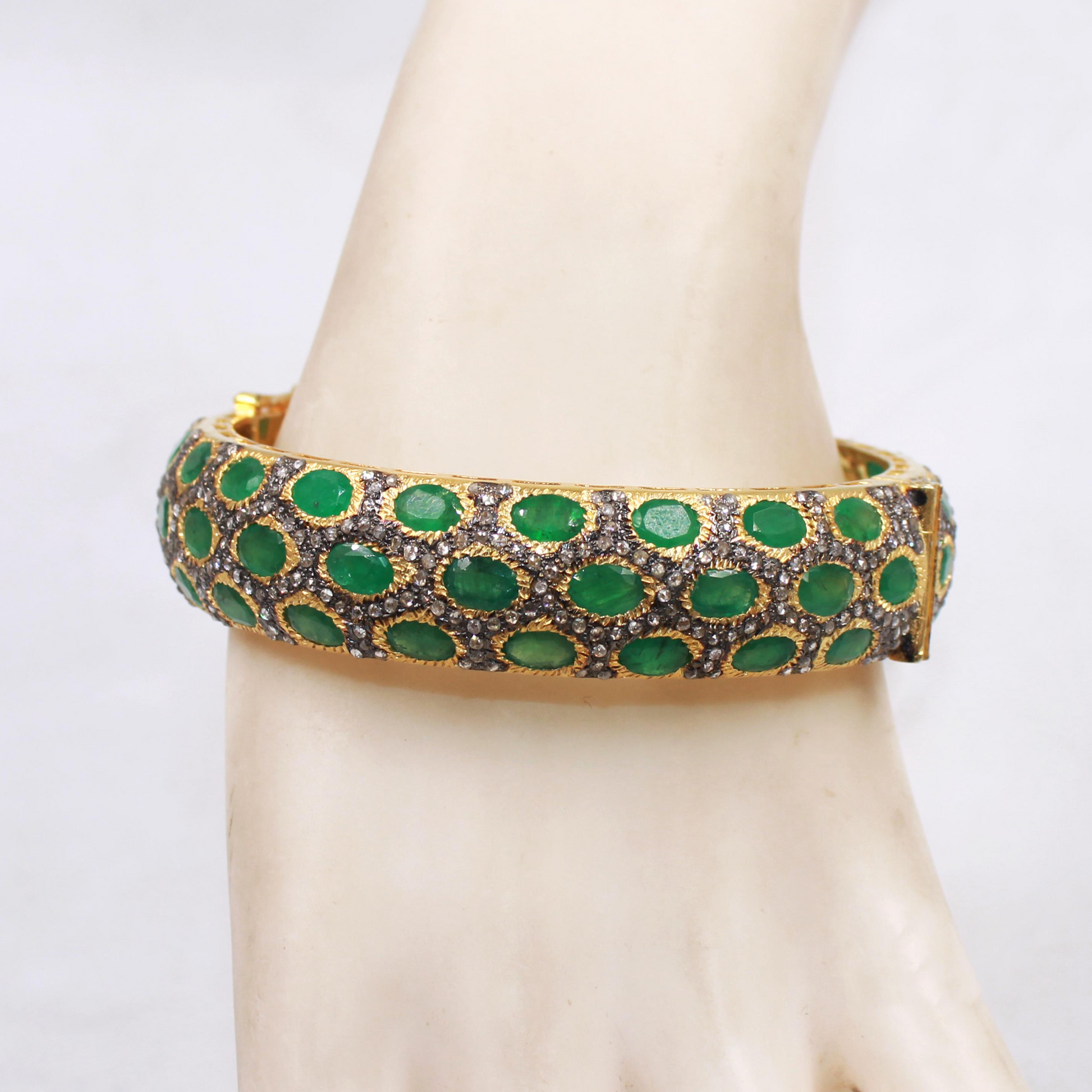 Green and gold bracelet on a mannequin wrist with a white background