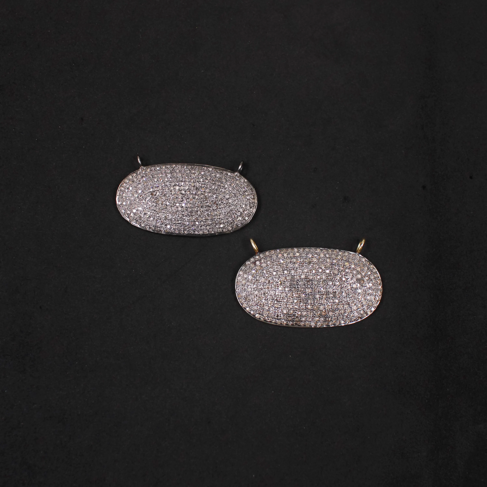 Pair of silver oval earrings on a black background