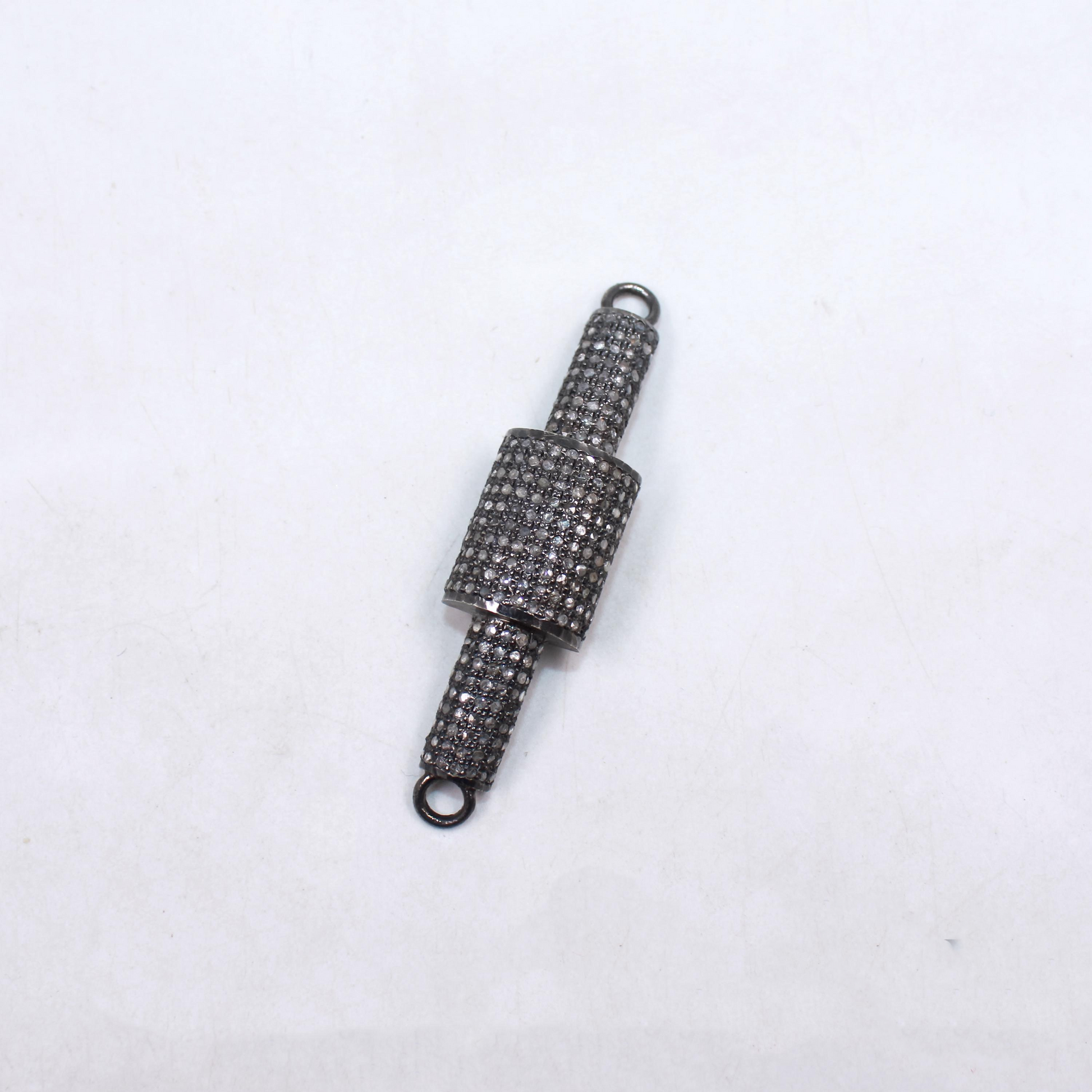 Decorative metal charm with intricate design on a white background