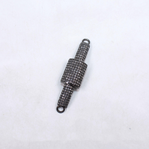 Decorative metal charm with intricate design on a white background