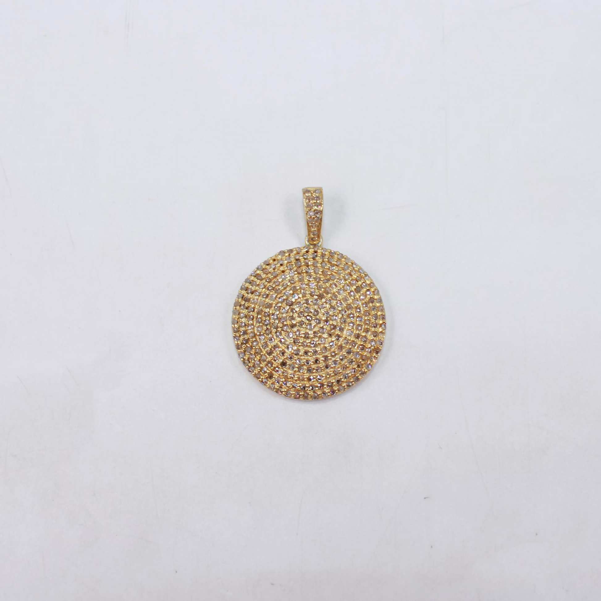 Gold circular pendant on a light gray background