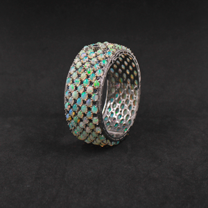 Silver ring with opal stones on a dark background