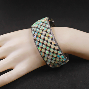 Opal bracelet on a hand against a dark background