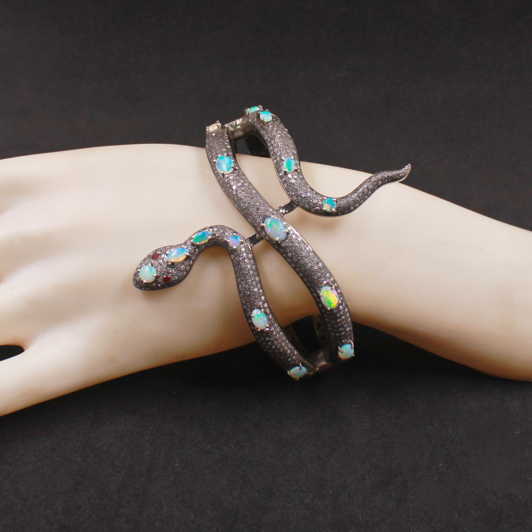 Decorative bracelet with gemstones on a mannequin hand against a dark background